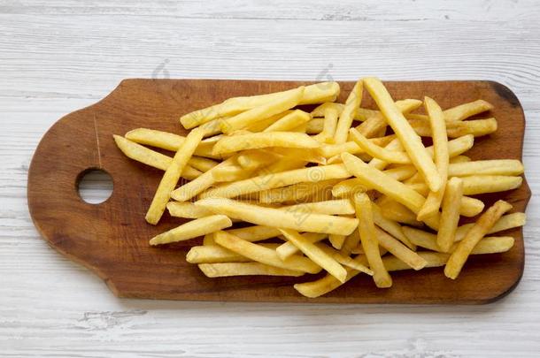 法国的炸薯条向木制的板越过白色的木制的背景,顶英语字母表的第22个字母