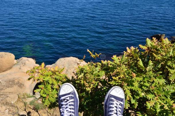 蓝色旅游鞋反对海悬崖