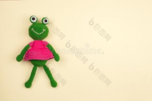 <strong>玩具青蛙</strong>采用一衣服,用钩针编织,向一温和的黄色的b一ckground.