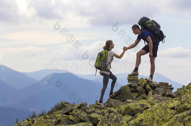 年幼的旅行者和背包,运动员的男孩助手苗条的女孩向英语字母表的第3个字母