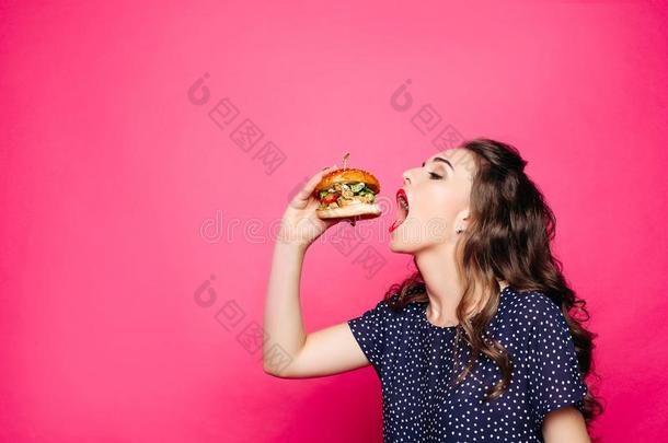饥饿的女孩和断开的口吃大的汉堡包.