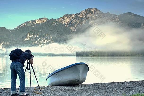 摄影师和眼睛在取景器是（be的三单形式迷人的照片关于湖和