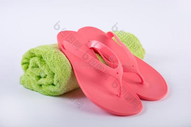 粉红色的凉鞋轻弹彻底失败向绿色的毛巾和白色的背景