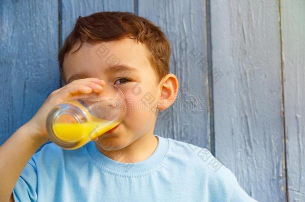 小孩小孩小的男孩喝饮料桔子果汁喝户外的copyspa公司