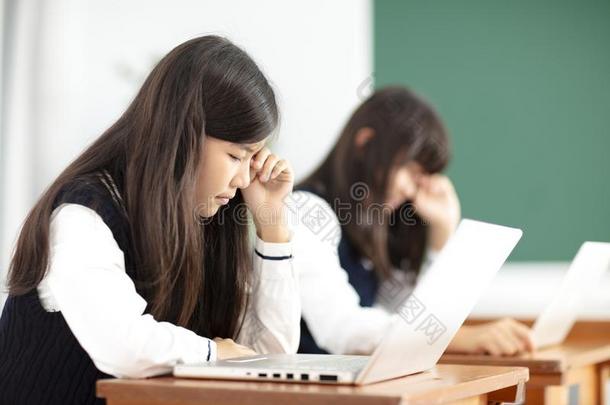 疲倦的少年男女<strong>学生学习</strong>和便携式<strong>电脑</strong>采用教室
