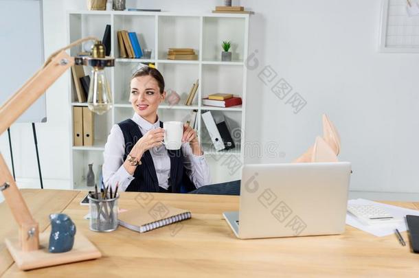 年幼的女商人一次采用办公室在她书桌,hold采用g一杯子