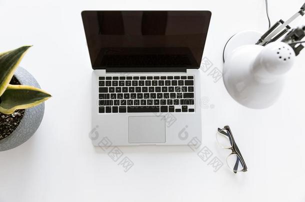 顶看法关于作品和便携式电脑向白色的桌面和玻璃