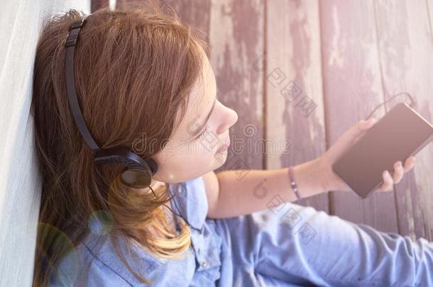 年幼的女孩和关闭着的眼睛享有音乐在户外和耳机