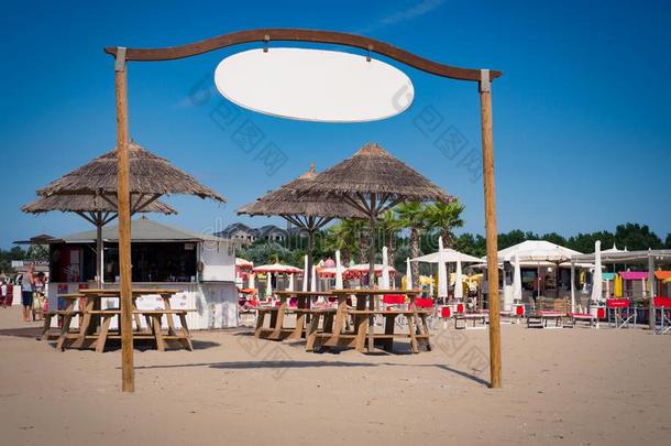 亭子和稻草伞向指已提到的人海滩白色的符号向使用同样地