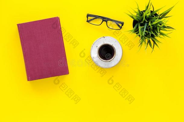 书和空的遮盖在近处眼镜,咖啡,植物向黄色的书桌