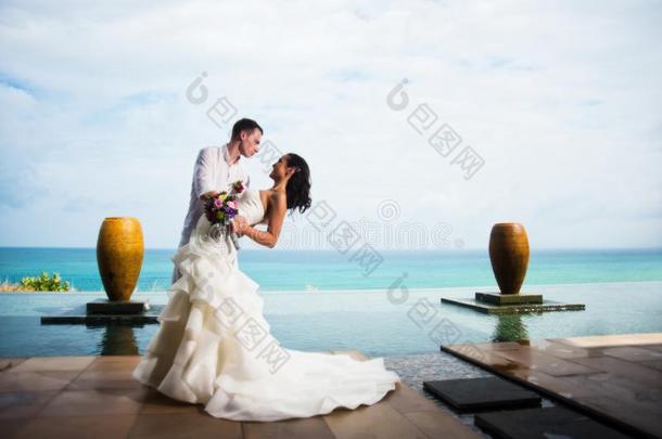 使整洁热烈地拥抱新娘向背景关于洋.浪漫的婚礼photographer摄影师
