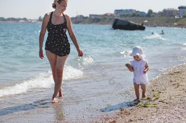 母亲和婴儿蹒跚<strong>行走的</strong>人女孩步行向指已提到<strong>的</strong>人海滩.海岸summarization摘要