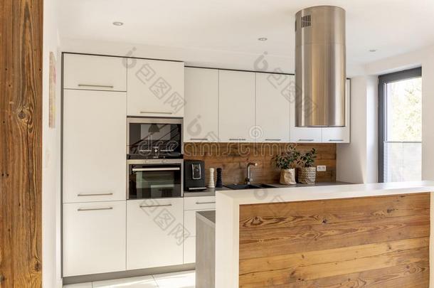白色的现代的厨房内部和银炊具兜帽在上面木材