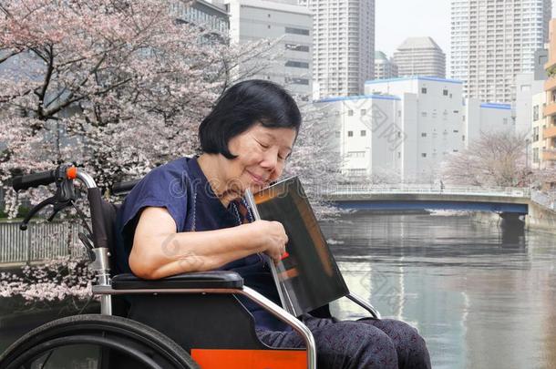 较高的亚洲人女人欲睡的在期间阅读弹药库采用公园