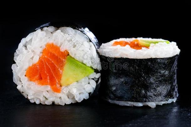 美味的寿司名册采用海苔和鳄梨和红色的鱼向黑暗的背