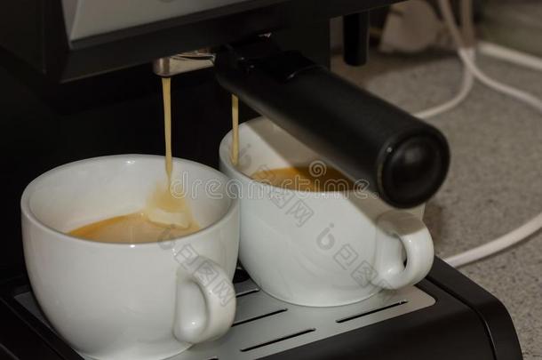 一浓咖啡机器和两个白色的杯子