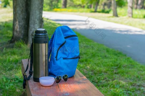 热水瓶,野营背包,茶水马克杯和太阳镜向一木制的是