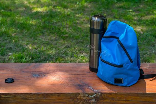 背包和热水瓶为野营向一木制的长凳