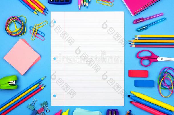 空白的有衬里的纸和学校<strong>日用品</strong>框架越过一蓝色b一ckgro