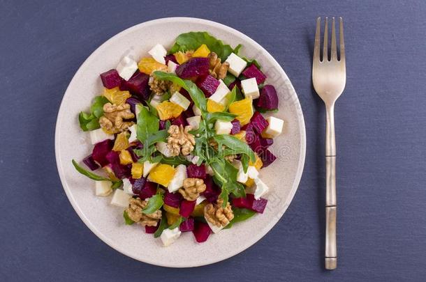 健康的素食者沙拉和甜菜根,绿色的芝麻菜,桔子,英语字母表的第6个字母