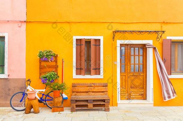 黄色的房屋和花,长凳和一自行车.富有色彩的房屋s