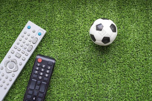 televisi向电视机遥远的控制和足球球向指已提到的人绿色的草.