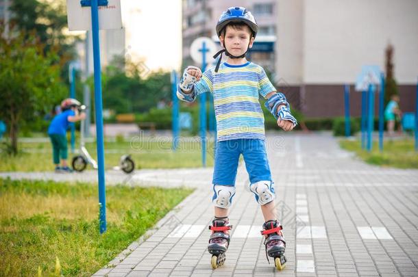 两个小孩男孩向滚筒溜冰鞋和他的<strong>兄弟兄弟</strong>向小型摩托车