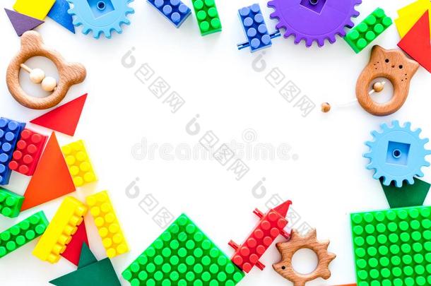 有色的建筑物玩具为孩子们框架向白色的背景