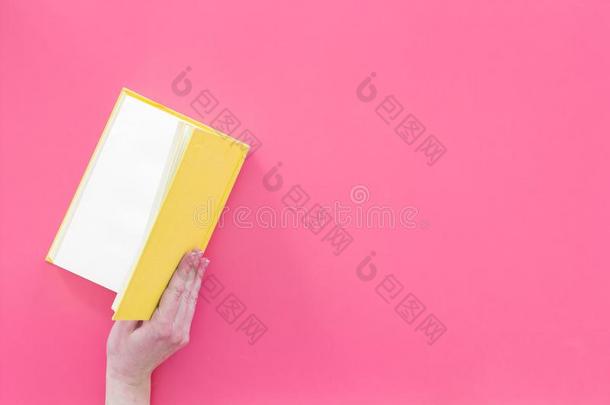 敞开的指已提到的人书.手拿住精装书书断开的向粉红色的后座