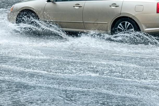 被水淹的城市路和<strong>汽车活动</strong>的和使溅起雨水