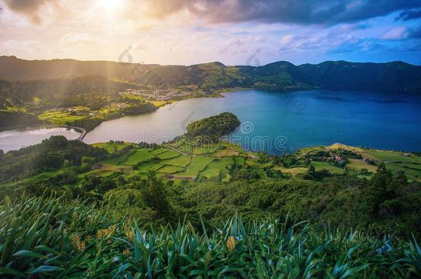 美丽的日落火山的湖经过山和绿色的葱翠的一