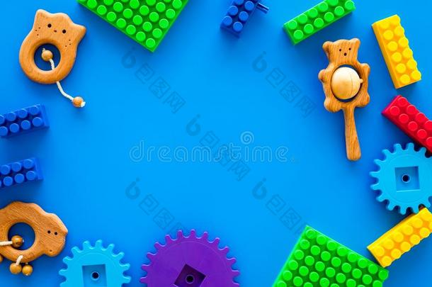 有色的建筑物玩具为孩子们框架向蓝色背景