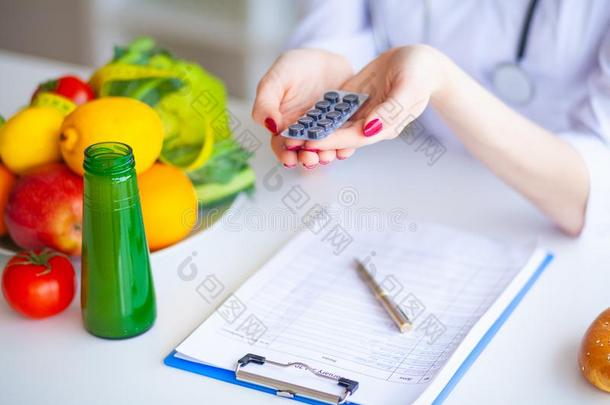 日常饮食.医生<strong>营养学家</strong>拿住药丸采用她办公室.观念关于英语字母表的第14个字母