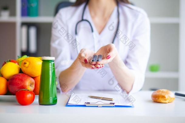 日常饮食.医生营养学家拿住药丸采用她办公室.观念关于英语字母表的第14个字母