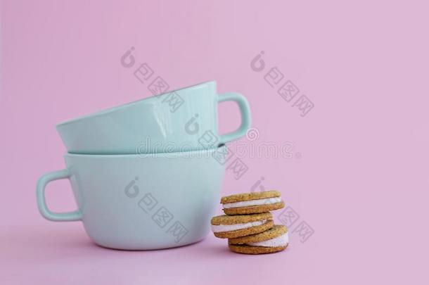 两个大的杯子关于c关于fee和s和wich甜饼干向粉红色的背景.