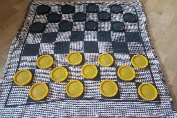 黑的和黄色的塑料制品西洋跳棋向织物西洋跳棋盘