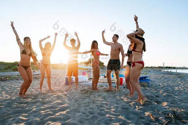 组关于朋友制造社交聚会向指已提到的人<strong>海滩</strong>在日落时间