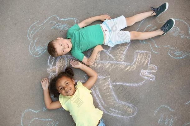 小的孩子们说谎在近处粉笔绘画关于飞机
