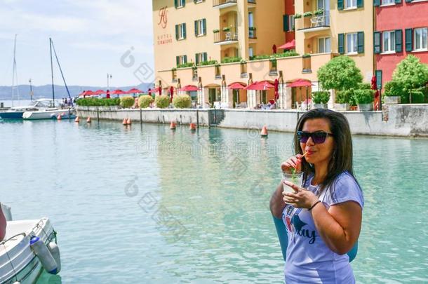 意大利.微笑的女人喝饮料冰寒冷的柠檬汽水向爱尔兰警察湖