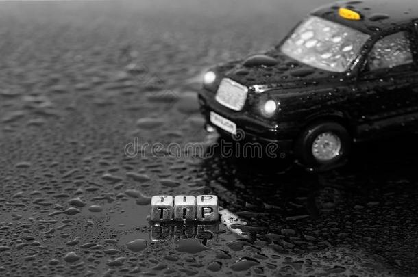 不列颠的传统的黑的出租车出租车玩具汽车和指已提到的人单词尖端向