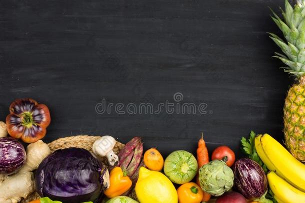 框架关于新鲜的蔬菜和成果向黑的粉笔背景.英语字母表的第3个字母