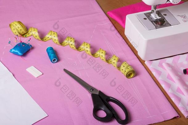 缝纫机器,厘米,粉笔和剪刀向粉红色的织物