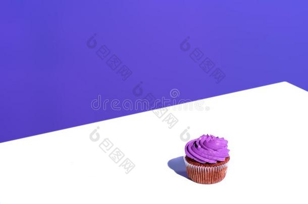 纸杯蛋糕和紫色的甜奶油酱装玻璃,向白色的