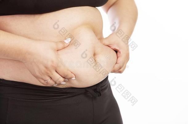一肥的女人试图抓取她肚子和她手,关-在上面
