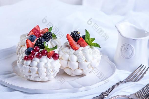 微妙的白色的蛋白糖饼和新鲜的浆果向指已提到的人盘子.白色的