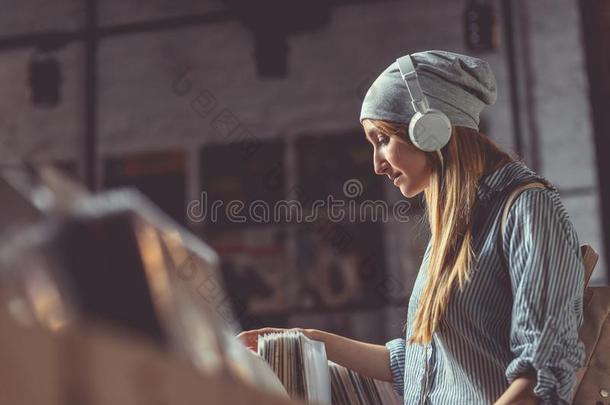 年幼的女孩和耳机采用一音乐商店