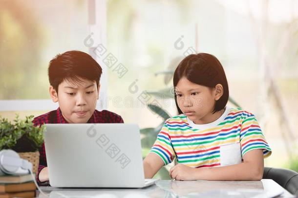 亚洲人小孩演奏便携式电脑计算机计算机同时