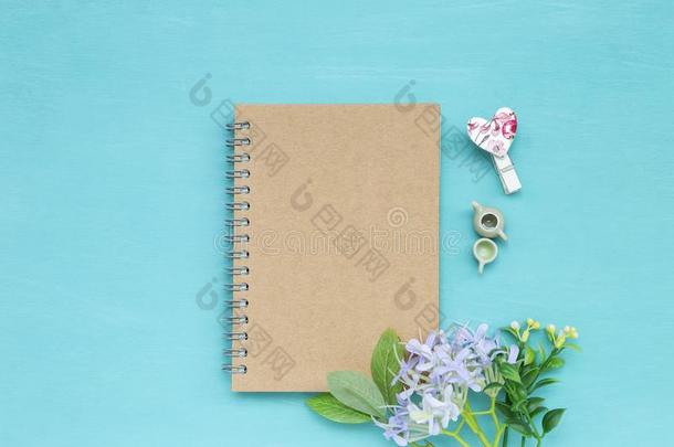 空白的眉遮盖笔记簿和小型的茶水罐和茶水杯子机智