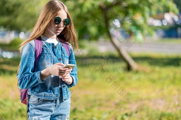 女孩女<strong>学生</strong>在的后面背包.<strong>打</strong>扮好的采用牛仔裤衣服和英文字母表的第19个字母