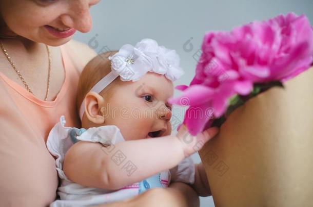 幸福的年幼的家庭.妈妈和她婴儿鄙视地说花